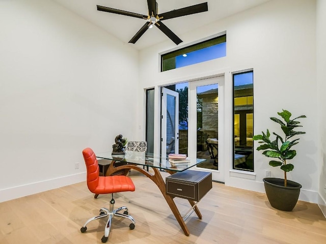 office area featuring a high ceiling, hardwood / wood-style floors, ceiling fan, and french doors