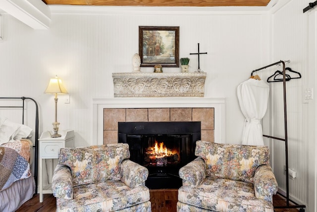 living area featuring a tiled fireplace and dark hardwood / wood-style flooring