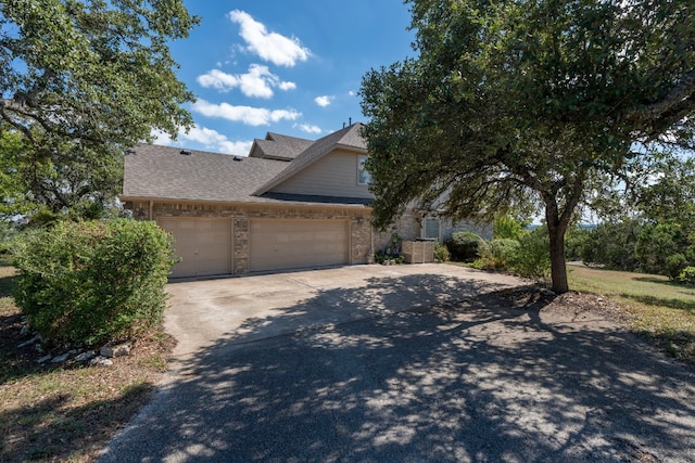 702 Timarron Dr, Leander, TX 78641 - view of front of property featuring an attached garage, brick siding, roof with shingles, and driveway