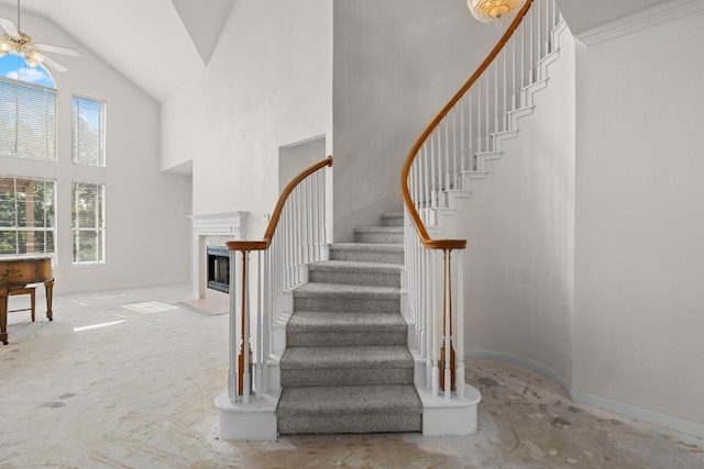 702 Timarron Dr, Leander, TX 78641 - stairway with high vaulted ceiling, a ceiling fan, and a fireplace with flush hearth