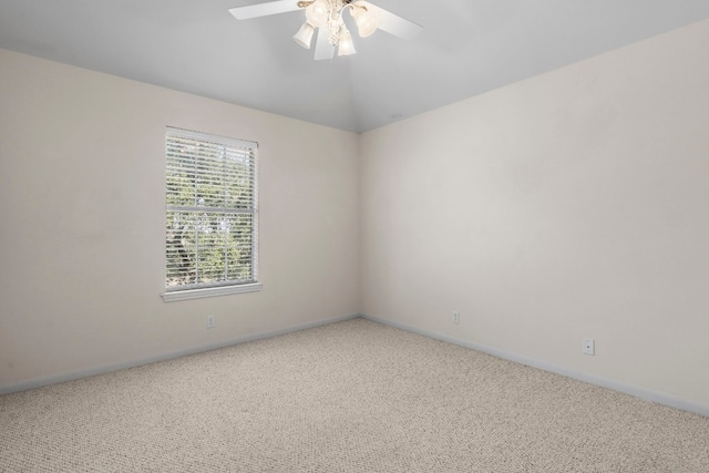 empty room featuring vaulted ceiling, ceiling fan, and carpet flooring