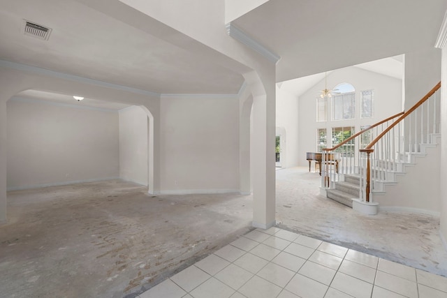 foyer entrance featuring ceiling fan, ornamental molding, and a towering ceiling