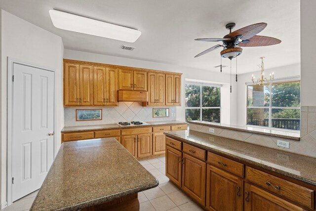 702 Timarron Dr, Leander, TX 78641 - kitchen featuring ceiling fan, tasteful backsplash, light tile patterned flooring, and brown cabinetry