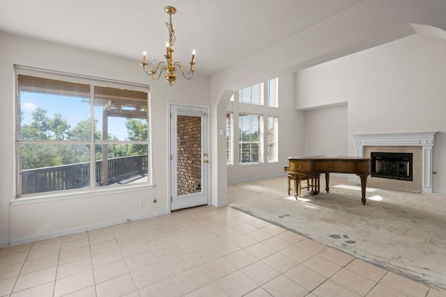 702 Timarron Dr, Leander, TX 78641 - unfurnished living room featuring a fireplace, a chandelier, light tile patterned floors, arched walkways, and light carpet