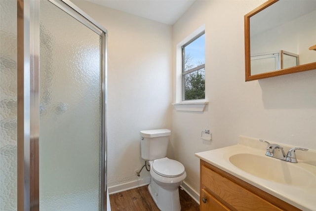 bathroom with vanity, wood-type flooring, toilet, and a shower with shower door