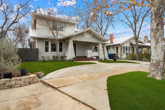 back of property featuring a lawn and covered porch