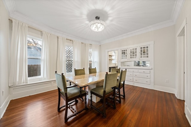 dining room with ornamental molding, a notable chandelier, and dark hardwood / wood-style flooring