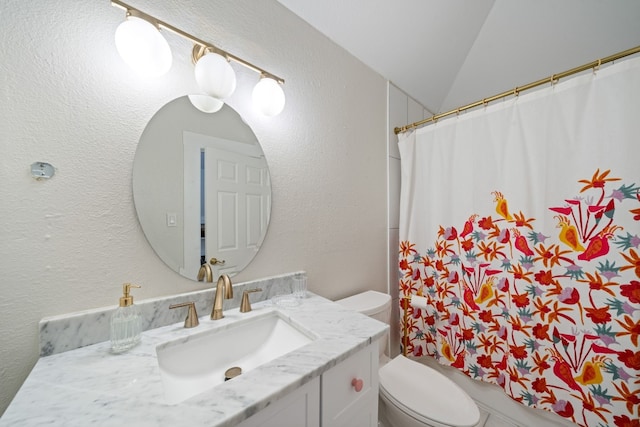 bathroom featuring lofted ceiling, vanity, and toilet