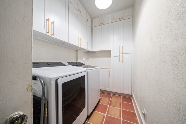 laundry room featuring light tile patterned flooring, cabinets, and washer and dryer