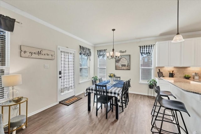 dining room with an inviting chandelier, hardwood / wood-style flooring, and ornamental molding