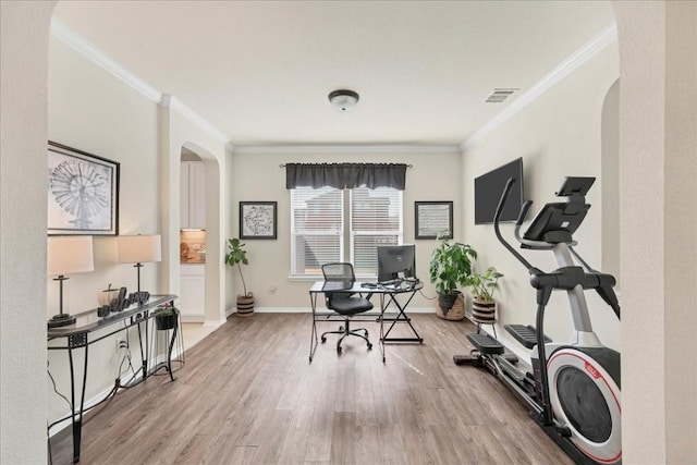 exercise area featuring hardwood / wood-style flooring and crown molding