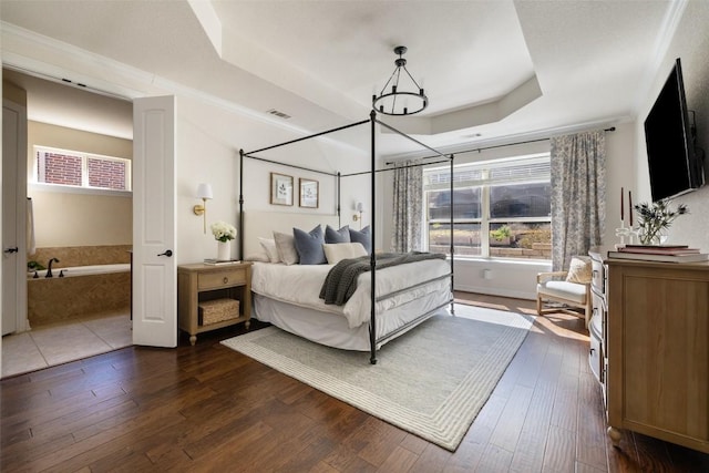 bedroom with a raised ceiling, crown molding, dark hardwood / wood-style floors, and a chandelier