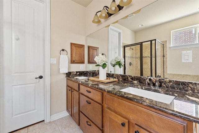 bathroom with an enclosed shower, vanity, and tile patterned flooring