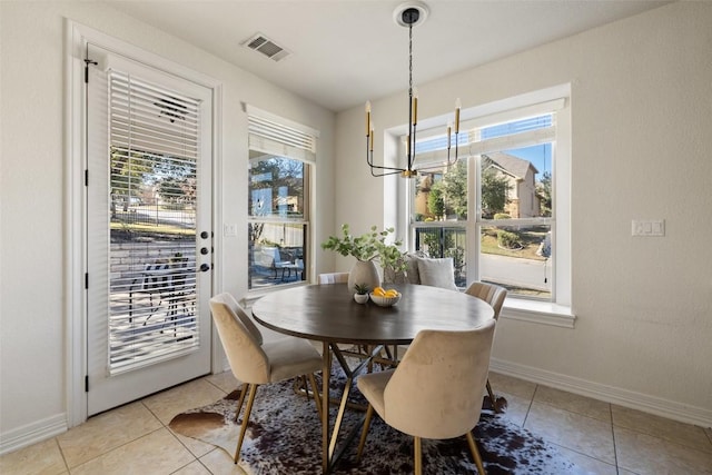 dining area with plenty of natural light, light tile patterned floors, and a chandelier