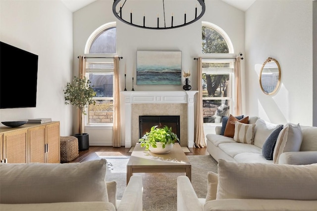 living room with a wealth of natural light, a high end fireplace, and light hardwood / wood-style floors