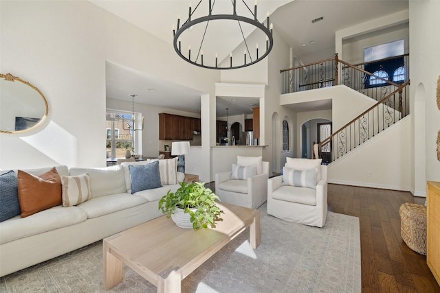 living room with hardwood / wood-style flooring, a high ceiling, and an inviting chandelier