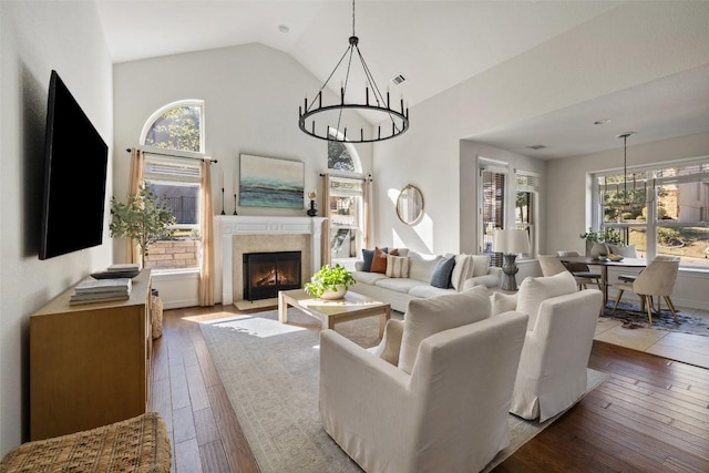 living room featuring an inviting chandelier, high vaulted ceiling, and hardwood / wood-style floors