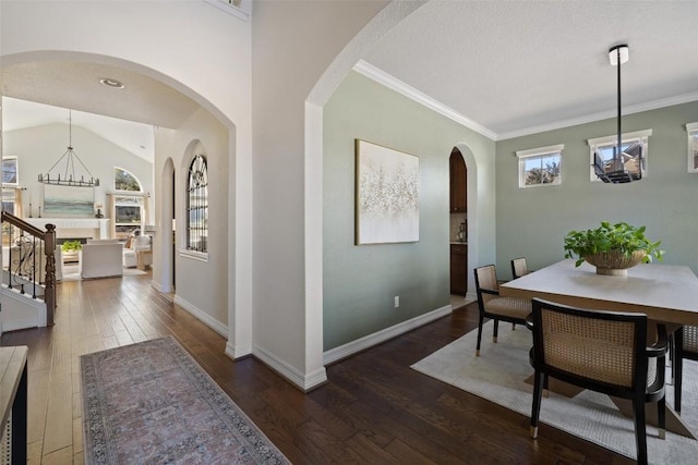 dining area featuring crown molding, lofted ceiling, and dark hardwood / wood-style flooring