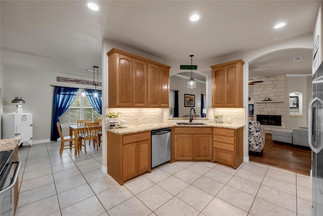 kitchen with pendant lighting, sink, light tile patterned floors, and appliances with stainless steel finishes