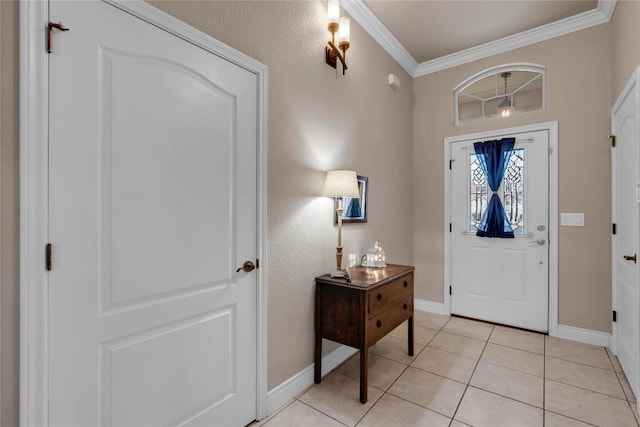 foyer entrance with light tile patterned floors and crown molding