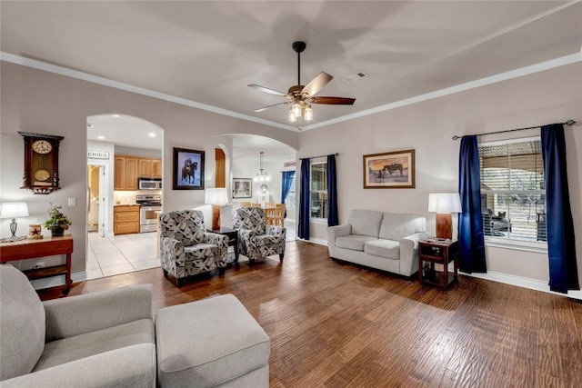 living room featuring ornamental molding, ceiling fan, and light wood-type flooring