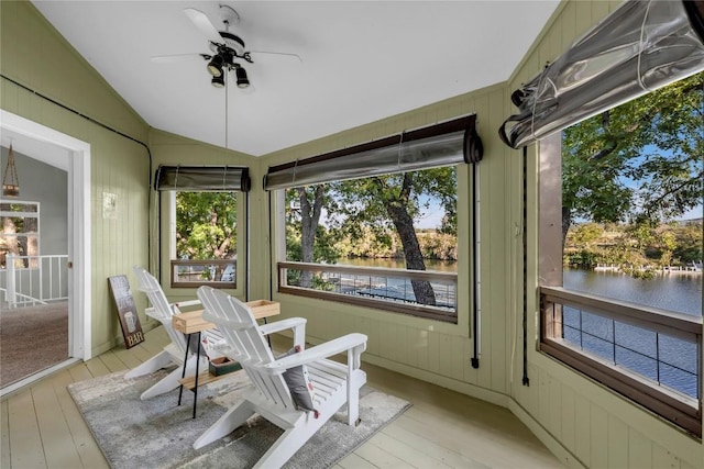 sunroom featuring a water view, ceiling fan, and vaulted ceiling