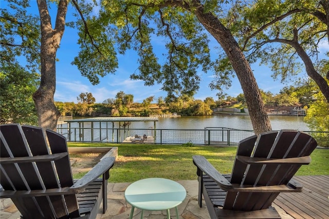 deck with a water view and a lawn