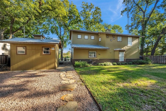 rear view of property featuring a lawn