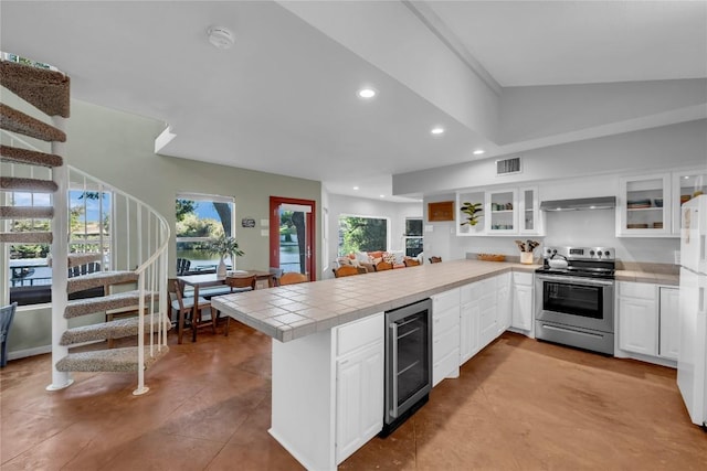 kitchen with electric stove, white cabinets, beverage cooler, and kitchen peninsula