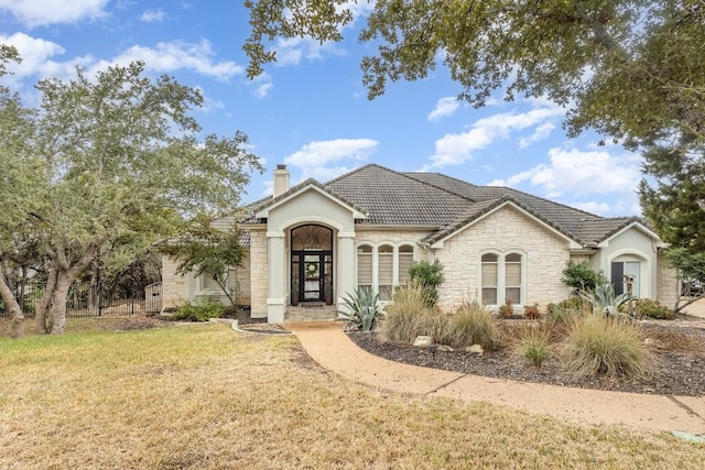 5019 Mcintyre Cir, Austin, TX 78734 - view of front of house with a chimney, stone siding, a front lawn, stucco siding, and a tiled roof