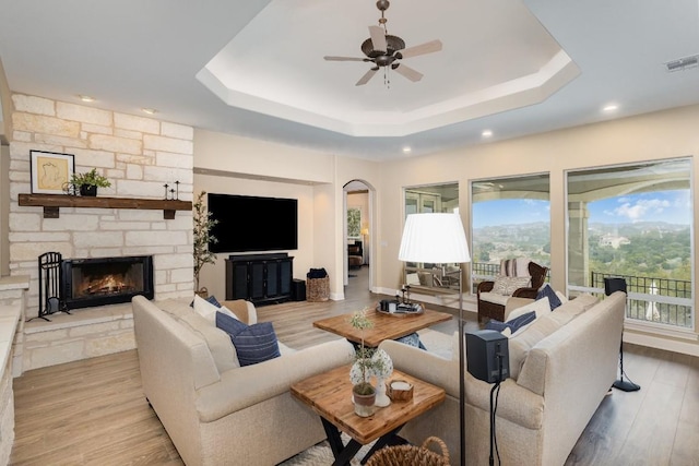 5019 Mcintyre Cir, Austin, TX 78734 - living room featuring a raised ceiling, plenty of natural light, ceiling fan, a stone fireplace, and recessed lighting