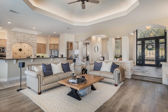 5019 Mcintyre Cir, Austin, TX 78734 - living area with arched walkways, a ceiling fan, a raised ceiling, light wood finished floors, and recessed lighting