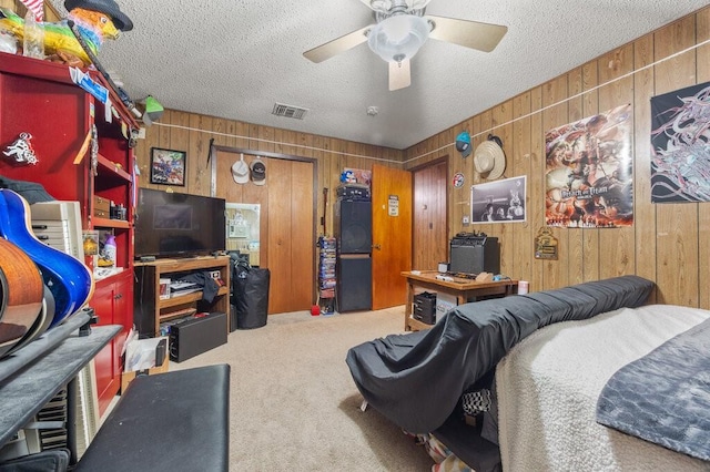 bedroom featuring carpet floors, a textured ceiling, and wood walls