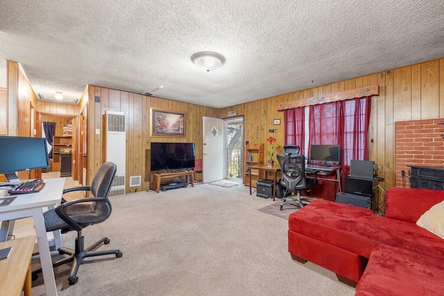 carpeted home office featuring a textured ceiling and wood walls