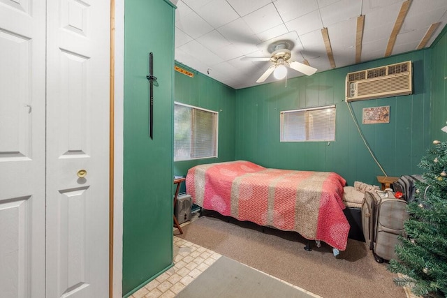 carpeted bedroom with ceiling fan and a wall mounted air conditioner