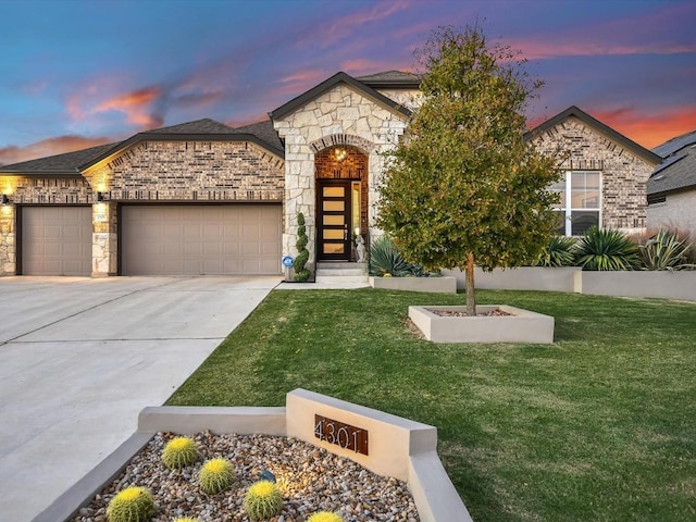 view of front of property featuring a garage and a yard