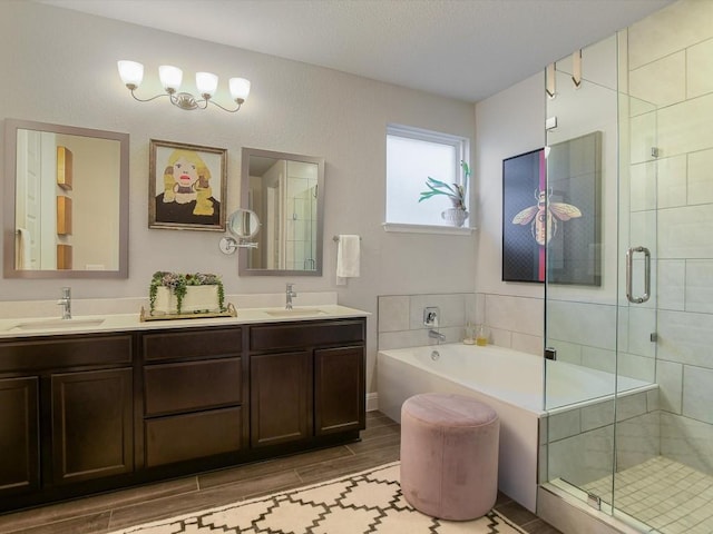 full bath featuring a shower stall, a sink, and wood finish floors