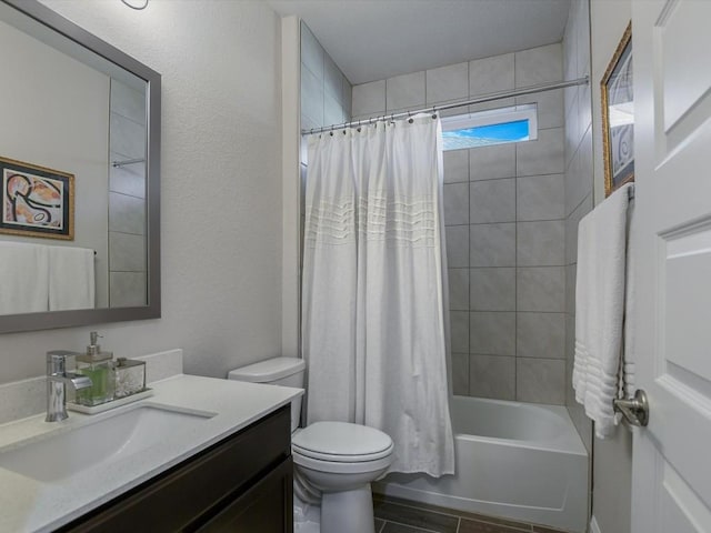 full bath featuring toilet, a textured wall, shower / bath combo, and vanity