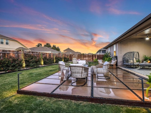 patio terrace at dusk featuring a fenced backyard and a lawn