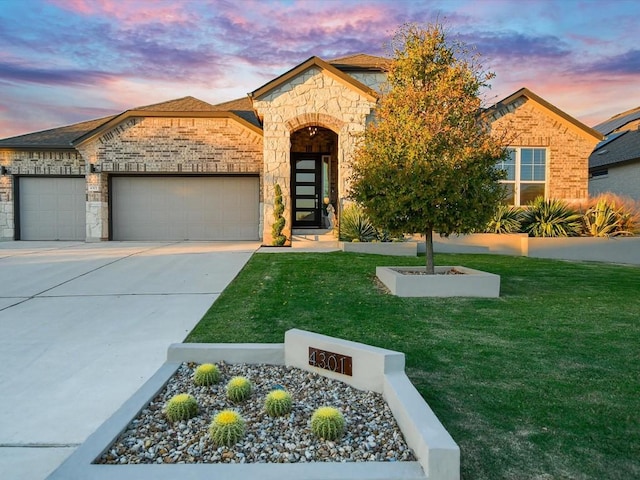 view of front facade with concrete driveway, a front lawn, an attached garage, and brick siding