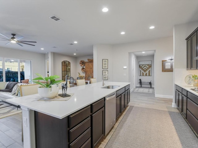 kitchen featuring a center island with sink, visible vents, open floor plan, a sink, and dishwasher