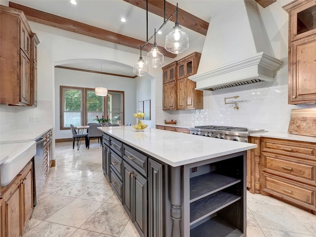 kitchen featuring a kitchen island, pendant lighting, beamed ceiling, dishwasher, and custom range hood