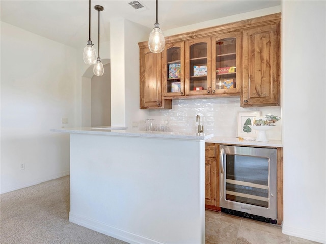 bar featuring sink, hanging light fixtures, decorative backsplash, and beverage cooler