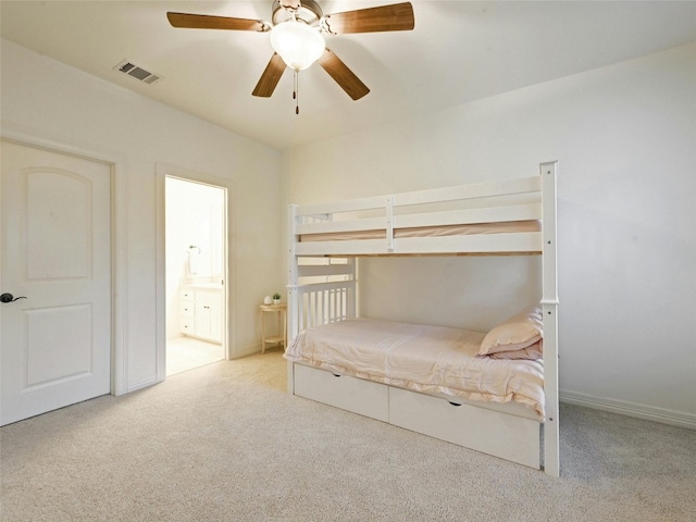 unfurnished bedroom with ceiling fan, light colored carpet, and ensuite bath