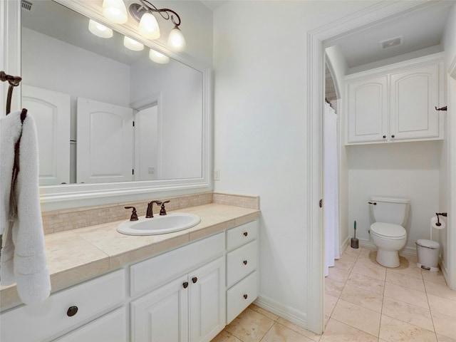 bathroom featuring vanity, tile patterned floors, and toilet