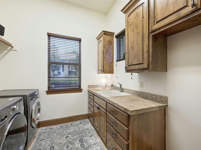 laundry room featuring sink, washing machine and dryer, and cabinets