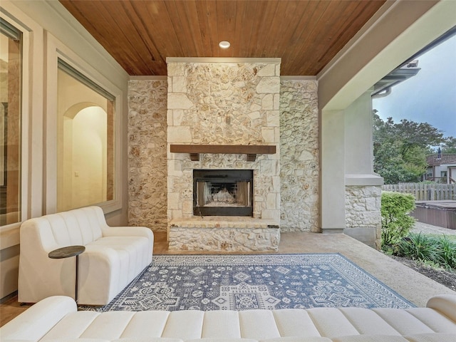 living room featuring wood ceiling and an outdoor stone fireplace