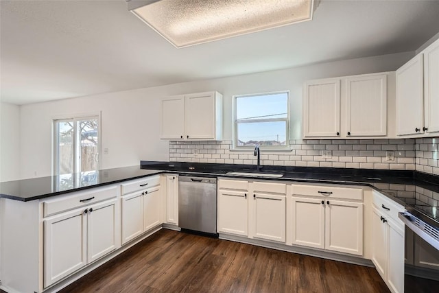 kitchen with appliances with stainless steel finishes, kitchen peninsula, sink, and white cabinets