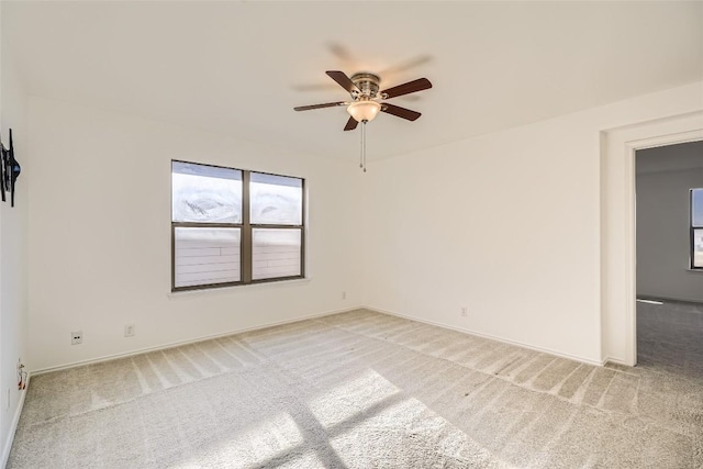 carpeted spare room featuring ceiling fan