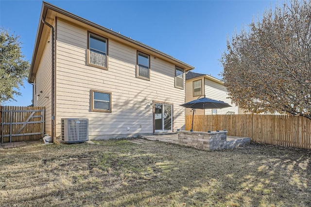 back of house with cooling unit, a patio area, and a lawn